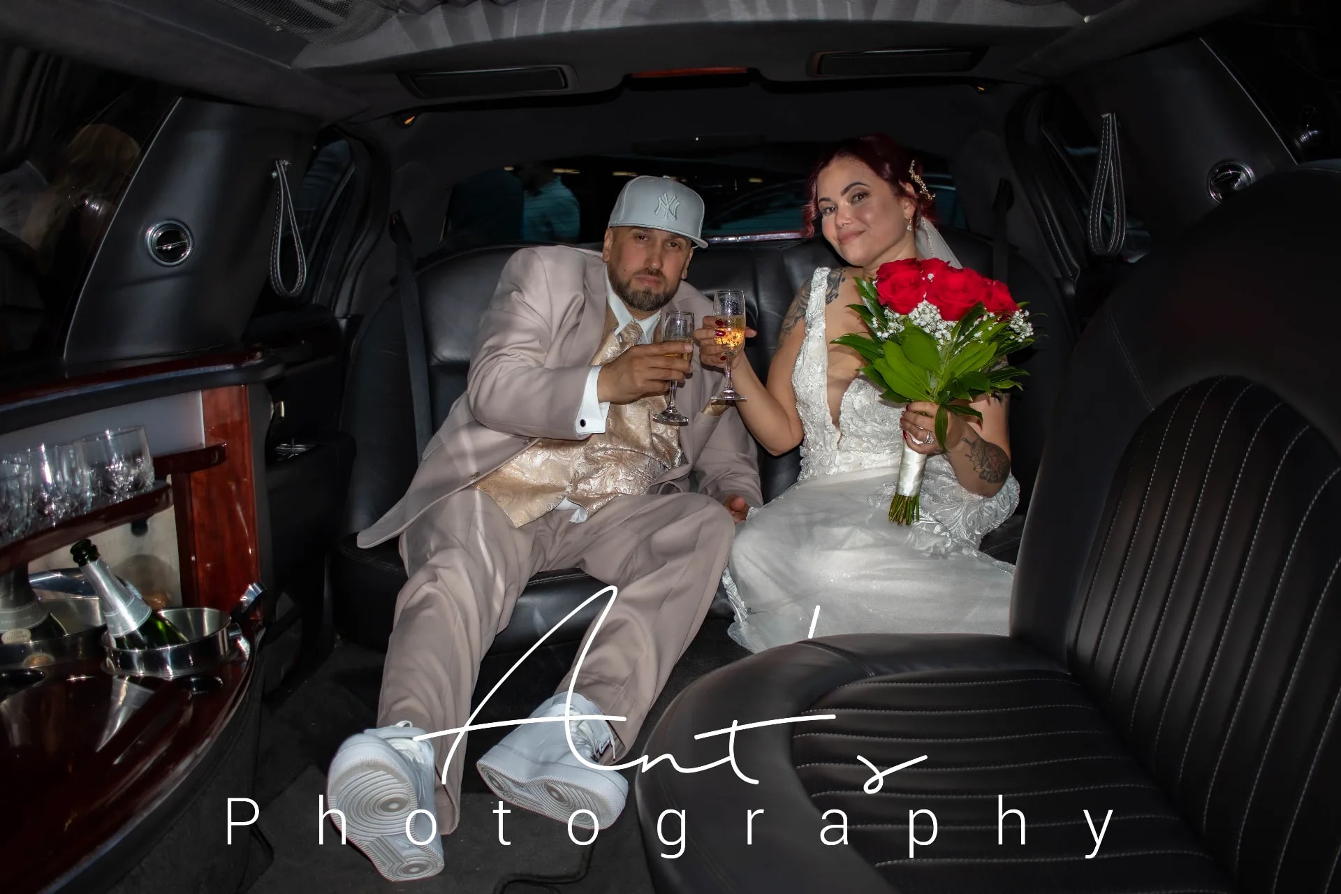 Bride and groom toasting with champagne flutes in the back of a limousine
