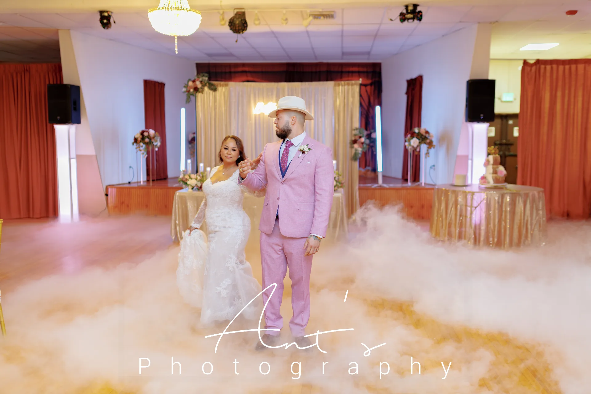 Bride and groom holding hands on a mist-covered dance floor at Falcon Rental Hall in New Britain