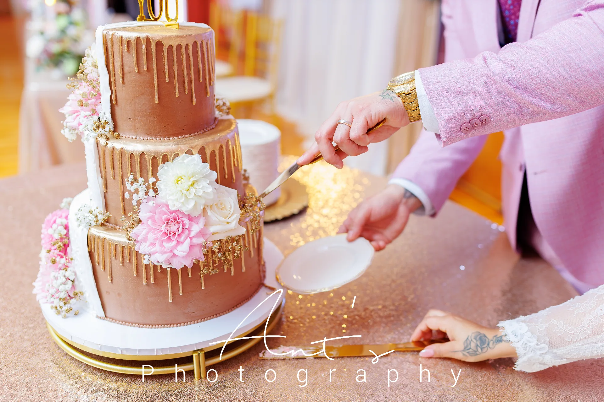 Newlyweds cutting a gold and white floral wedding cake at Falcon Rental Hall in New Britain